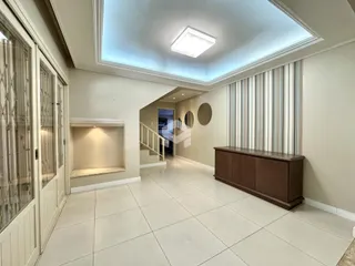 Hall de entrada com piso de cerâmica claro e parede neutra.