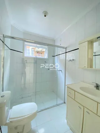 Foto de um banheiro interno com revestimento branco e box de vidro.