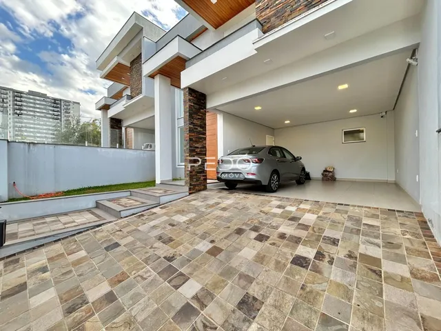 Vista da fachada de uma casa moderna em Lajeado, Brasil, com área externa pavimentada.