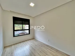 Sala de estar com piso de madeira clara e paredes brancas.
