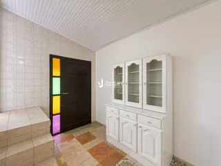 Vista interna de uma área com escadaria e porta em um imóvel.