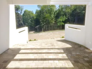 Vista de uma área pavimentada externa com paredes brancas