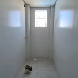 Corredor interno com paredes brancas e piso claro.