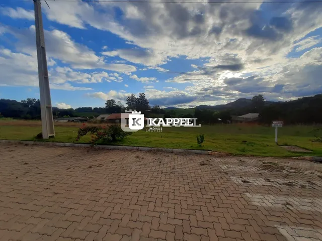 Vista de campo aberto com colinas ao fundo sob um céu nublado.