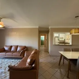 Foto interna de uma sala de estar com sofá e piso de cerâmica.