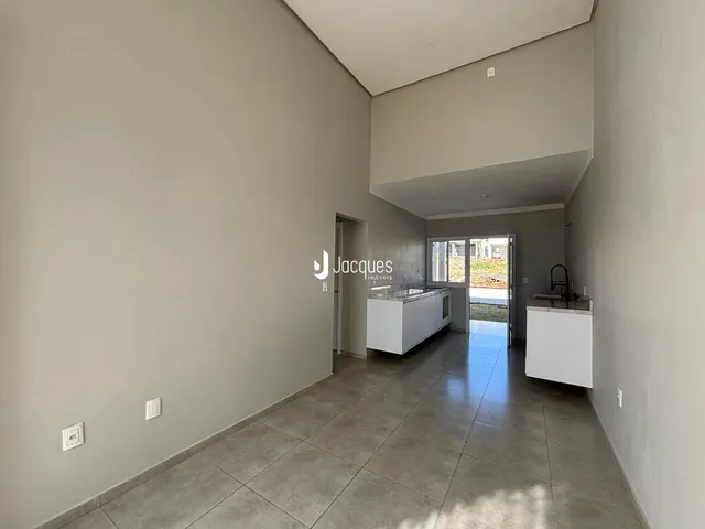 Corredor interno de uma residência com piso de cerâmica e paredes brancas.