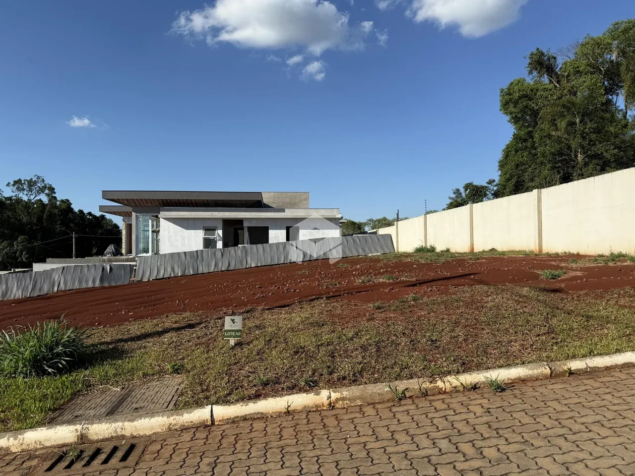 Vista externa de uma residência moderna em Lajeado, Brasil, com área de terreno em terra.