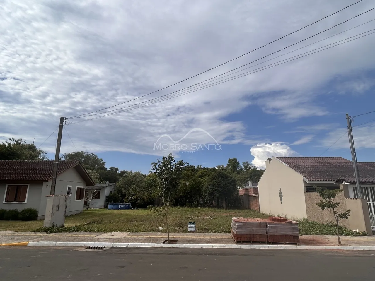 Fachada de uma residência em Lajeado, Brasil, com área externa gramada e vegetação.