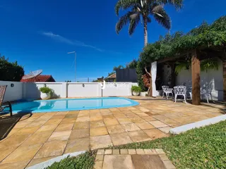Vista da piscina e área externa com deck.