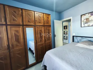 Quarto com armários de madeira e cama em um ambiente azul claro.
