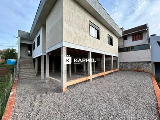 Fachada de uma casa moderna em Lajeado, Brasil, com área externa de cascalho.