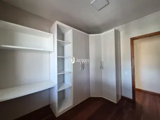 Foto de um ambiente interno com armários brancos e piso de madeira.