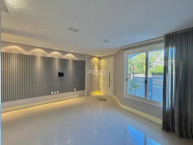 Ambiente interno de uma sala de estar moderna com piso claro e paredes neutras.