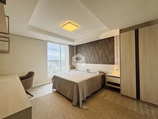Quarto com cama e armários em um apartamento em Lajeado.