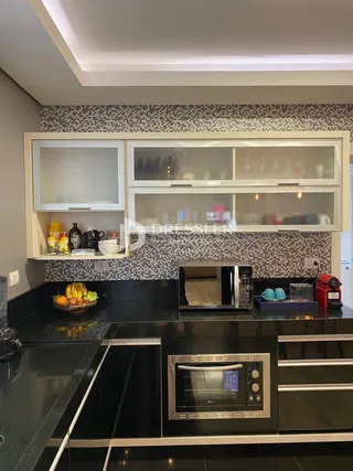 Cozinha moderna com armários e eletrodomésticos embutidos.