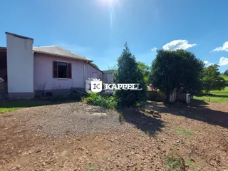 Fachada de uma residência em Lajeado, Brasil, com vegetação ao redor.