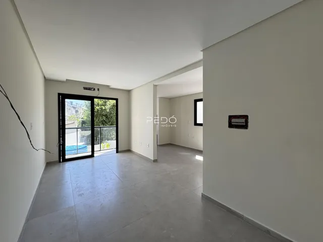 Interior de um ambiente com paredes brancas e piso cinza.