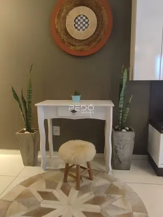 Sala de estar com parede decorada e plantas em um ambiente interno.