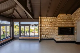 Sala de estar com pé direito alto e parede de tijolos expostos.