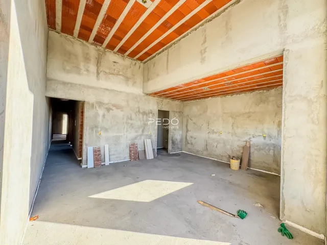 Imagem de um ambiente interno em construção com paredes de concreto aparente.