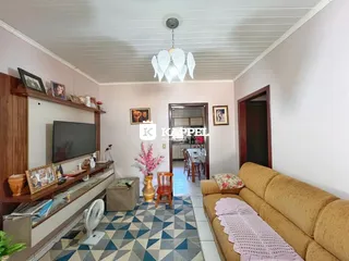 Sala de estar com sofá e televisão em um ambiente claro.