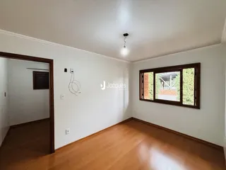 Sala de estar com piso de madeira e janela.