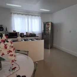Ambiente interno com mesa grande e janela iluminada.