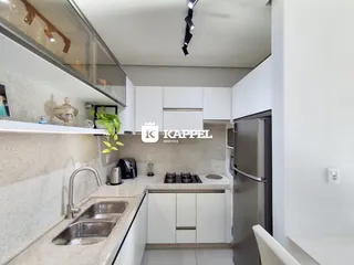Cozinha moderna com armários brancos e bancada clara.