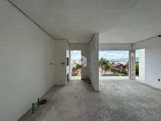 Vista de um corredor interno com paredes brancas e piso de concreto.