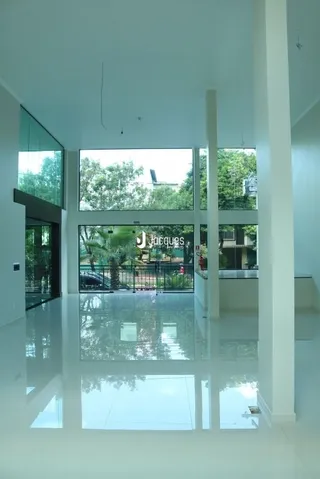 Vista interna de um ambiente moderno com grandes janelas de vidro.
