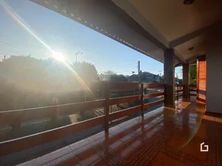 Vista da varanda com piso de cerâmica e grade de segurança.