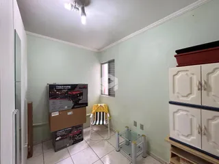 Interior de uma sala com paredes verde-claro e móveis brancos.