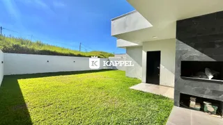 Vista externa da residência com gramado verde bem cuidado.