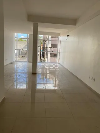 Corredor interno com piso de cerâmica refletindo a luz natural.