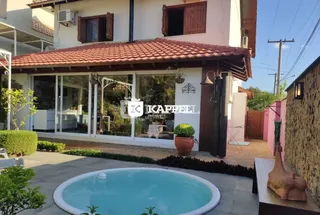 Foto da fachada de uma casa em Lajeado, Brasil, com uma piscina no primeiro plano.
