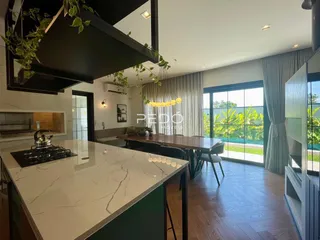 Ambiente de sala de jantar e cozinha com vista para o jardim.