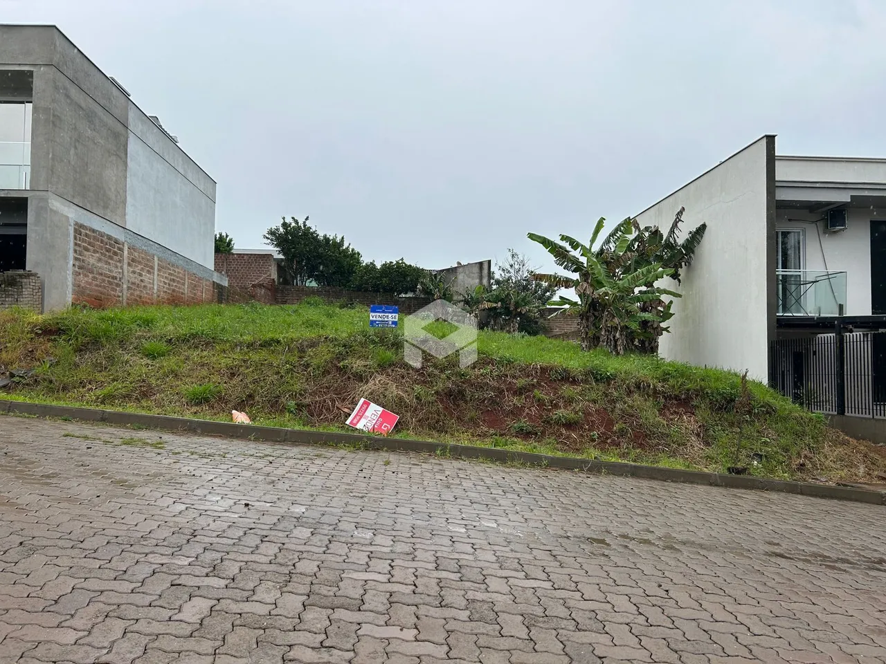 Fachada de uma residência em Lajeado, Brasil, com terreno inclinado.