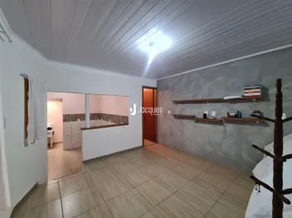 Vista interna de uma sala com piso de cerâmica e prateleiras de madeira.