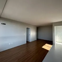 Ambiente interno com piso de madeira e paredes claras.