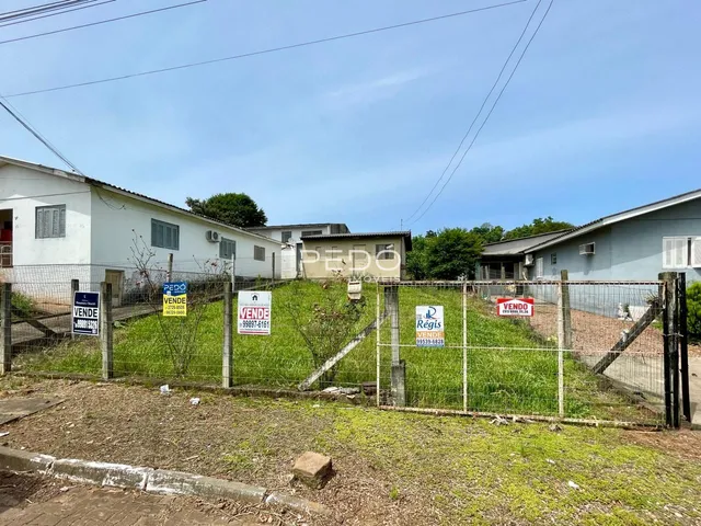 Vista externa de uma propriedade com cerca e vegetação na frente.