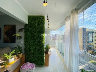 Vista de um corredor interno com parede verde e grande janela de vista para a cidade.