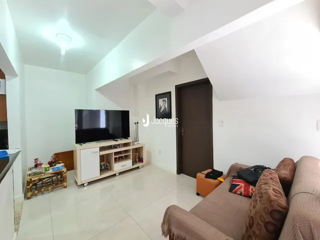 Sala de estar com televisão e sofá em um imóvel no Brasil.