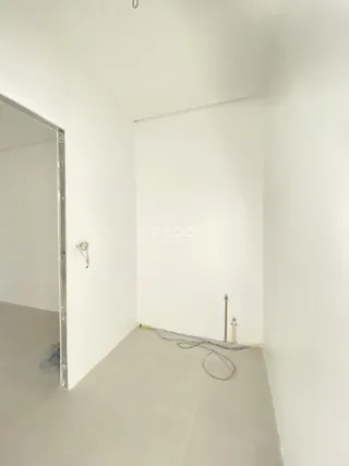 Interior de um cômodo com paredes brancas e piso claro.