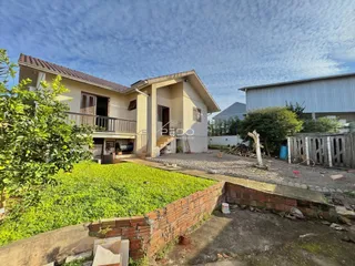 Fachada de uma casa em Lajeado, Brasil, com jardim e muro de tijolos.