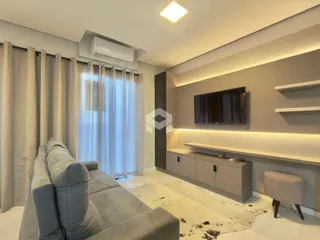Sala de estar com sofá e televisão em um apartamento.