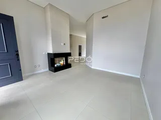 Sala de estar com lareira e piso claro em um imóvel no Brasil.