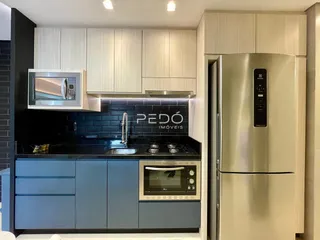 Cozinha moderna com armários azuis e eletrodomésticos em aço inoxidável.