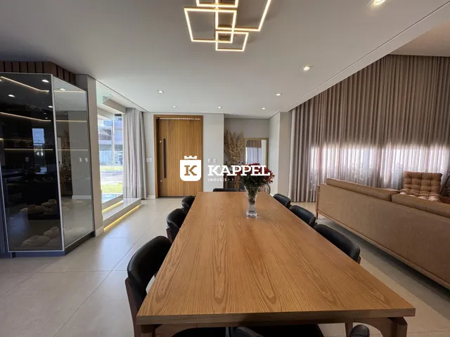 Uma foto de um ambiente interno com uma mesa de jantar de madeira.