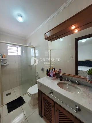 Vista de um banheiro com revestimento cerâmico e bancada de mármore.