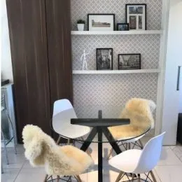 Foto de uma sala de estar com uma poltrona clara e painel de parede.